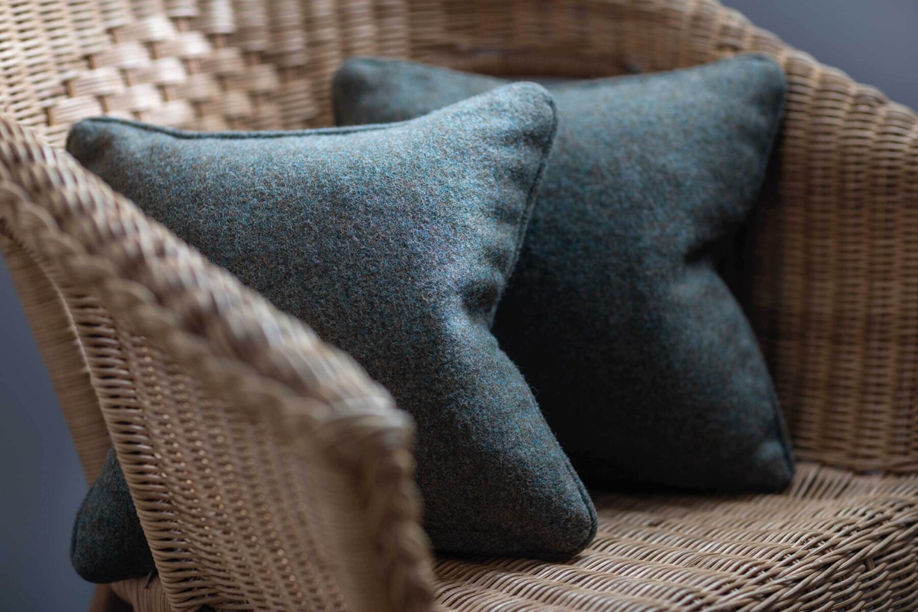 Blue tweed cushions and basket chair at Kylesku Hotel, Scotland.