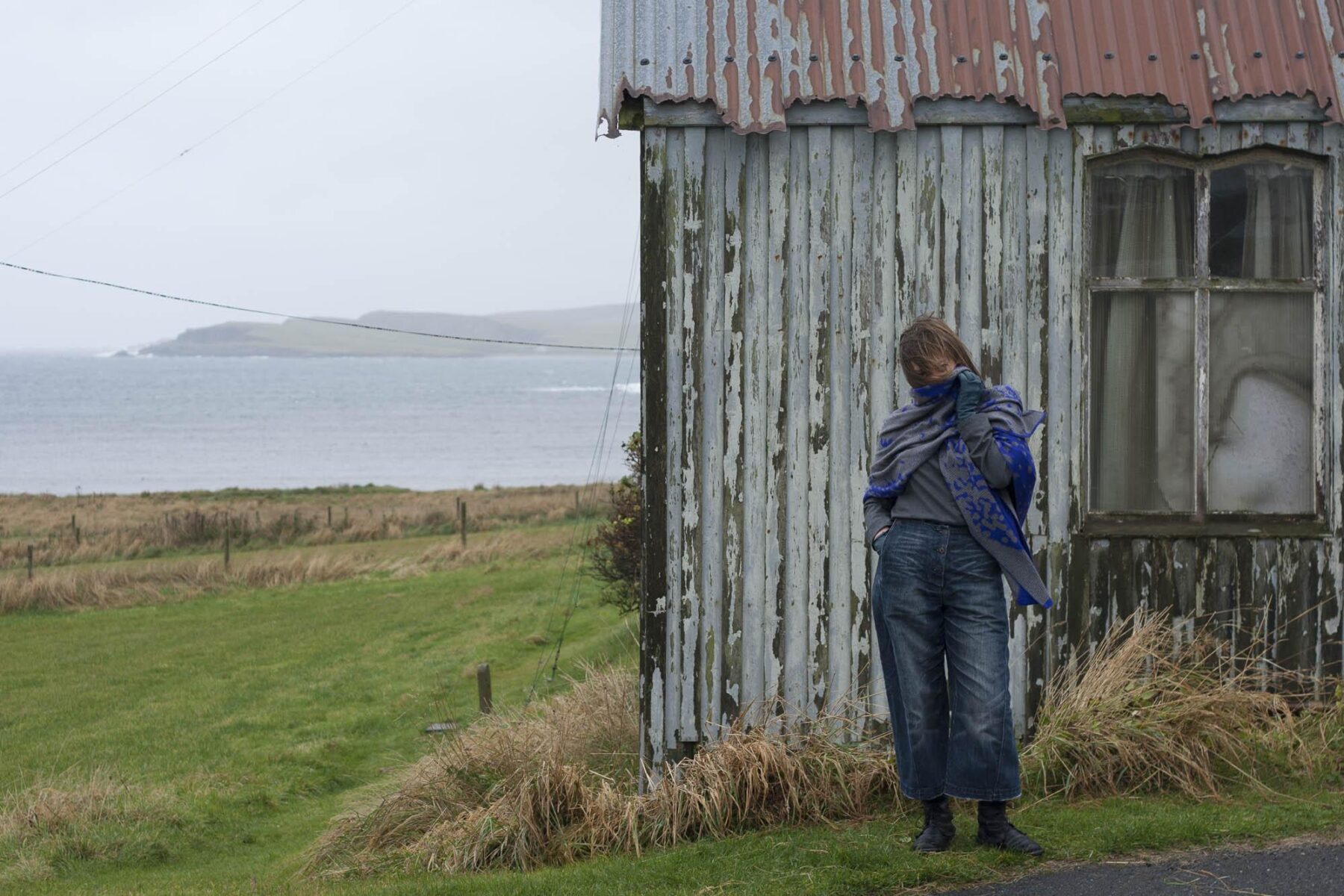 Gail Turpin in a test shot in front of landscape and building in Hoswick, Shetland for Nielanell.