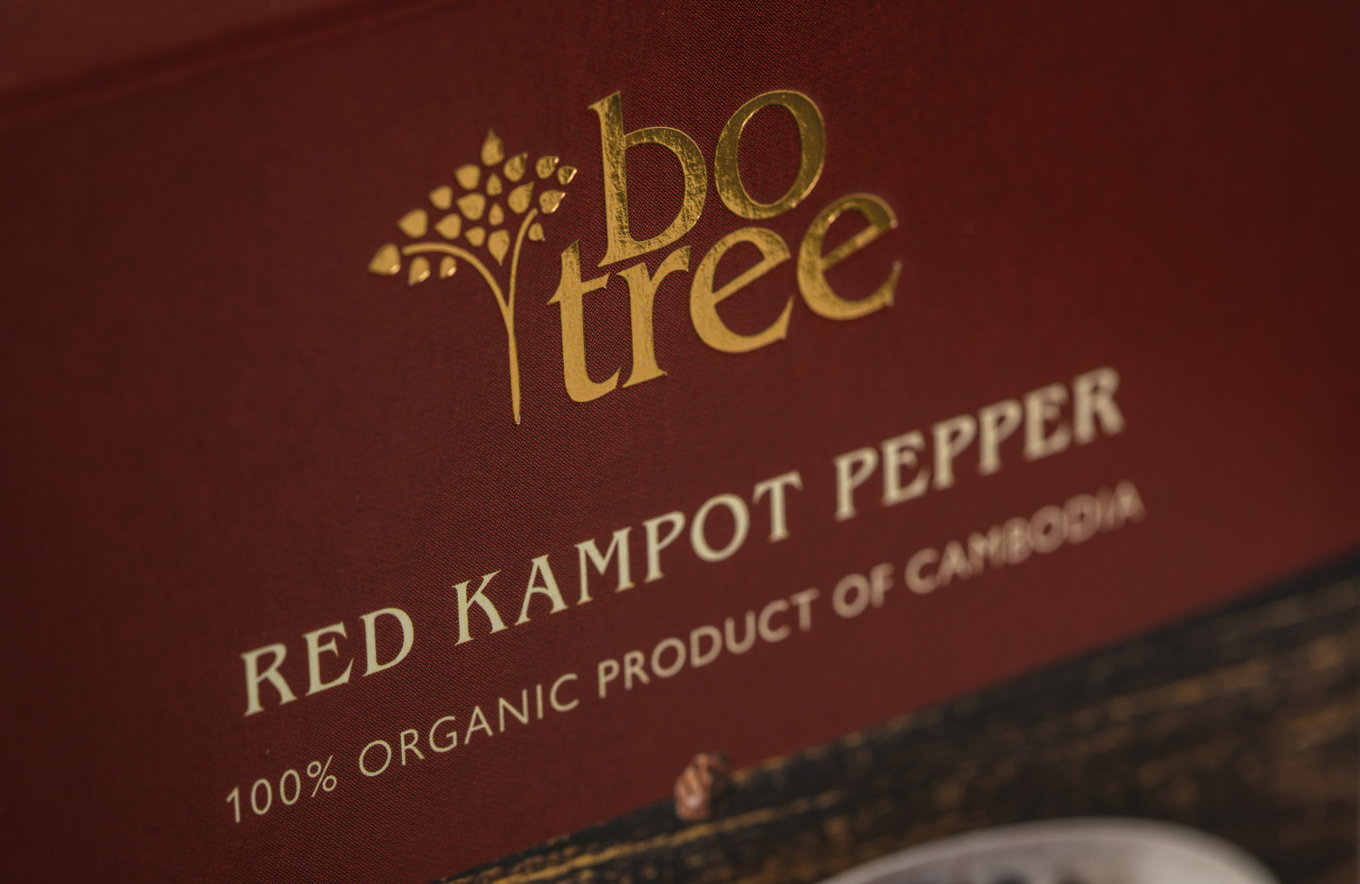 Close-up of gold foil Botree logo on Red Kampot pepper packaging.