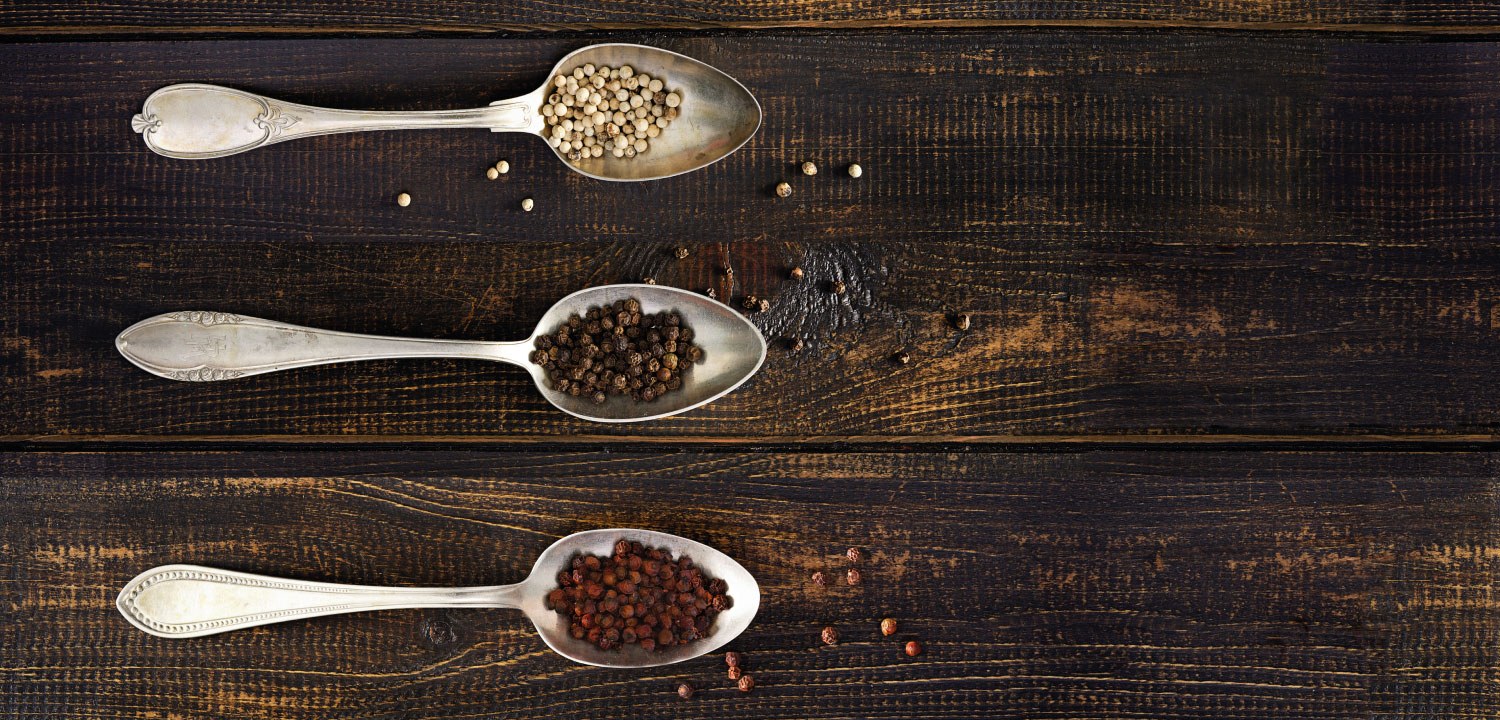 Photo of 3 silver spoons containing Kampot white, black and red peppercorns.
