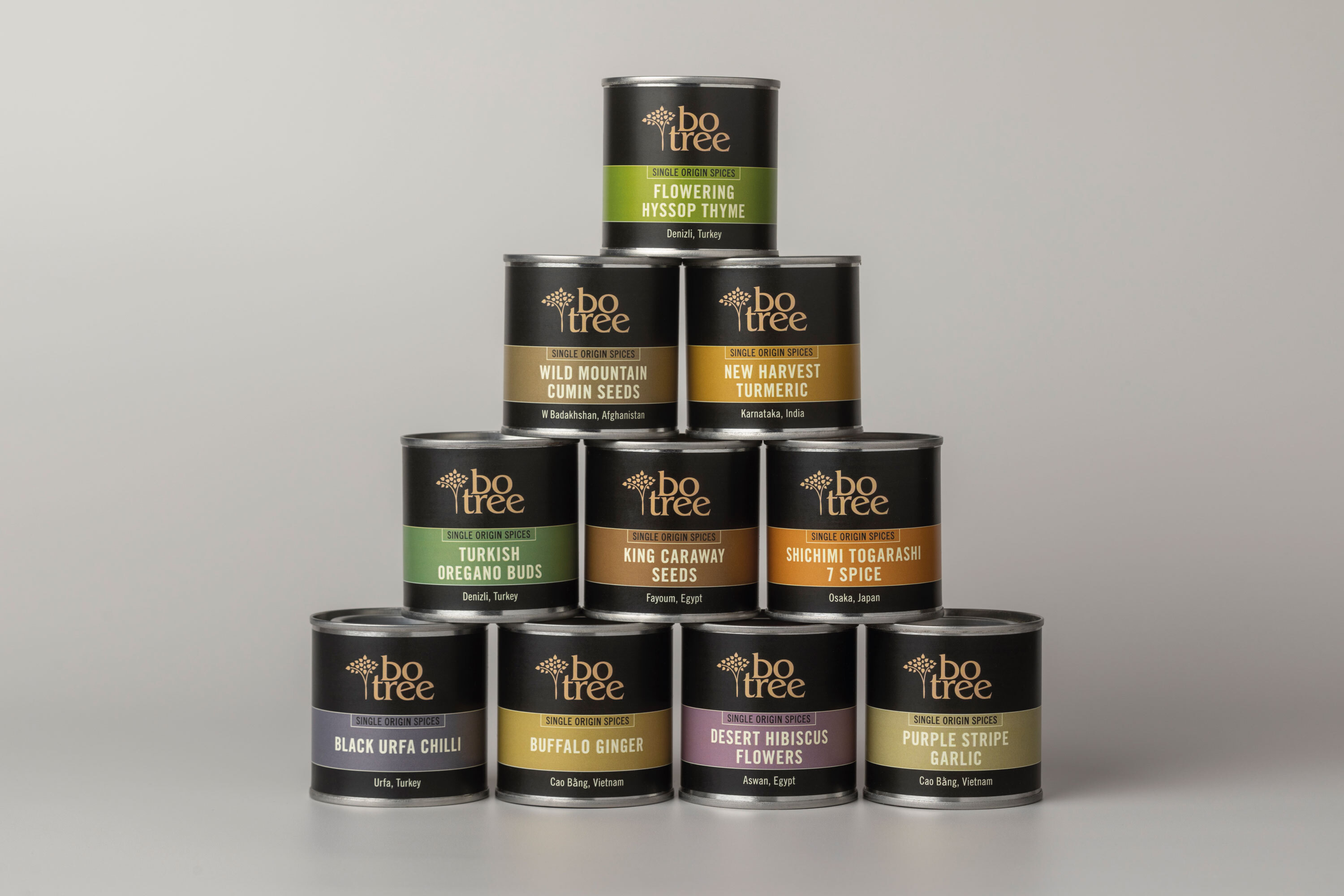 Stack of 10 Botree single-source spice tins. Dark brown, gold coloured logo and colour coded panels.