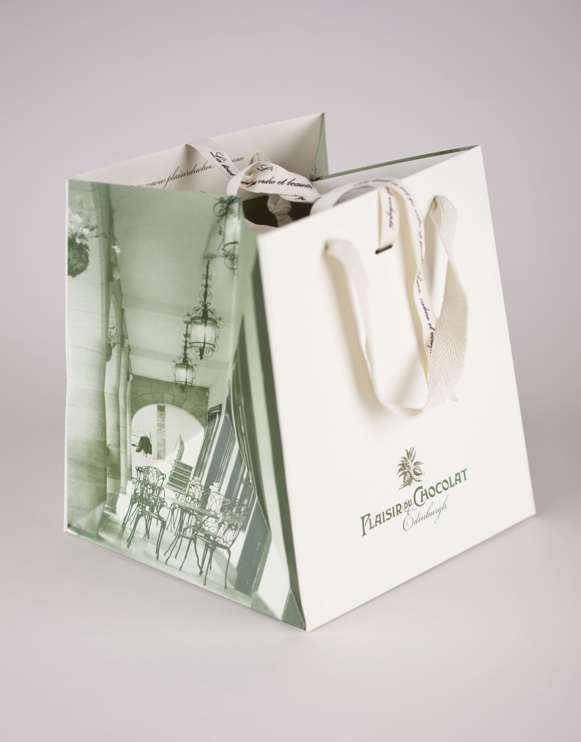 'Glam' bag with duotone green image, cream front and back and cream ribbon. Plaisir du Chocolat logo.