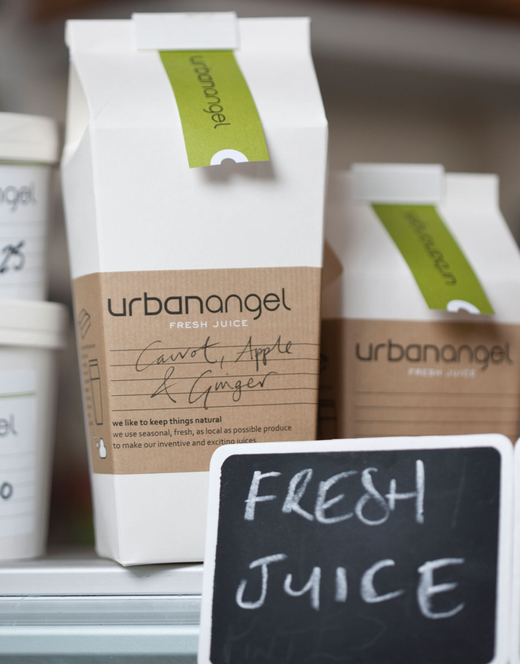 Urbanangel take-away packaging with kraft labels and green branded neck labels.